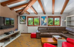 a living room with a couch and a table at Gorgeous Home In Sveti Vid Dobrinjski With House A Panoramic View in Gostinjac