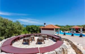 a circular patio with two stools and a pool at Gorgeous Home In Sveti Vid Dobrinjski With House A Panoramic View in Gostinjac