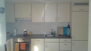 a kitchen with white cabinets and a sink at Downtown Switzerland/Bodensee/Zurich in Ermatingen