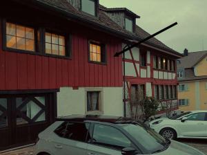 a car parked in front of a red and white house at Downtown Switzerland/Bodensee/Zurich in Ermatingen