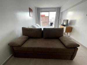 un sofá en una sala de estar con ventana en Deluxe apartment in great location en Buenos Aires