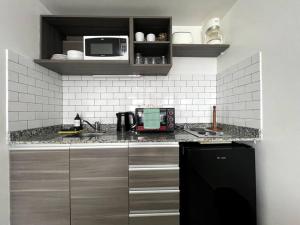 cocina con fregadero y microondas en Deluxe apartment in great location en Buenos Aires