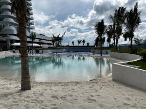 a swimming pool with palm trees and a building at Haldis Suites in San Fernando