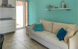 - un salon avec un canapé blanc et des oreillers bleus dans l'établissement 1 Bedroom Stunning Home In Baia S, Anna Budoni, à Tanaunella