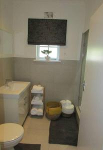 uma casa de banho com um WC e um lavatório em Lovely 1-bedroom rental with a pool em Cidade do Cabo