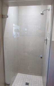um chuveiro com uma porta de vidro na casa de banho em Lovely 1-bedroom rental with a pool em Cidade do Cabo