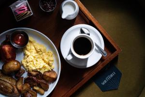 una mesa con un plato de huevos y patatas y una taza de café en Kimpton Saint George Hotel, an IHG Hotel, en Toronto