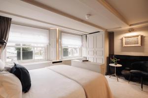 a bedroom with a large bed and two windows at Hotel 717 in Amsterdam