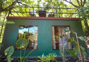 een klein huis met een balkon erboven bij La Casa de la Montaña in Monteverde Costa Rica