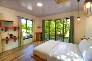 1 dormitorio con cama y ventana grande en La Casa de la Montaña, en Monteverde