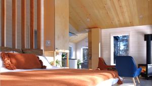 um quarto com uma cama e uma cadeira azul em Charlevoix expérience thermale en pleine nature - Suites Nature Charlevoix - Suite #1 em Les Éboulements