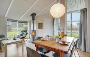 une salle à manger avec une table, des chaises et une grande fenêtre dans l'établissement Stunning Home In Askeby With Sauna, à Askeby