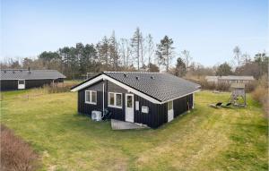 una casita blanca y negra en un campo en Awesome Home In Askeby With 4 Bedrooms, Sauna And Wifi en Askeby