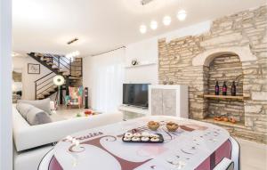 a living room with a white couch and a stone wall at Cozy Home In Sajini With Outdoor Swimming Pool in Šajini
