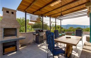 a patio with a fireplace and a table and chairs at Awesome Home In Kornic With Kitchen in Kornić