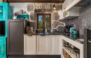 コーニッチにあるAwesome Home In Kornic With Kitchenのキッチン(白いキャビネット、青い電化製品付)