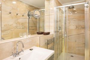 a bathroom with a sink and a glass shower at BHG Apartments Prague in Prague