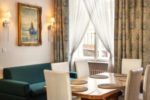 a dining room with a table and chairs and a couch at BHG Apartments Prague in Prague