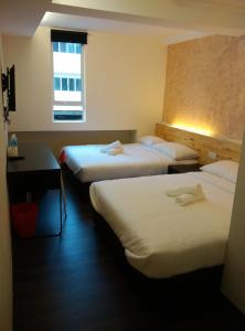 una camera d'albergo con due letti e una finestra di Dream Garden Hotel a Klang