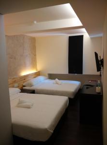 una camera d'albergo con tre posti letto di Dream Garden Hotel a Klang