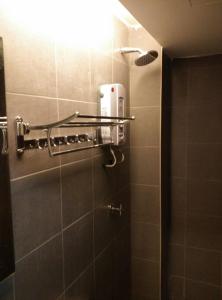 baño con ducha con una luz en la pared en Dream Garden Hotel, en Klang