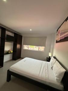 a bedroom with a large white bed with a window at Hotel River Side in San Martín