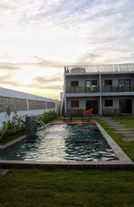 une maison avec une piscine en face d'un bâtiment dans l'établissement Pousada Sal e Sol, à São Miguel do Gostoso