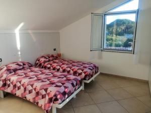 1 dormitorio con 2 camas y ventana en SOLELUNA, en Albenga