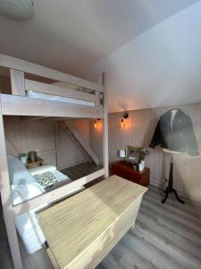 a bedroom with two bunk beds and a desk at La Pierre des Volcans Chaleureux Calme Champêtre in Aydat