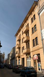 a large building with cars parked in front of it at 1900 Vetus Central Apartment in Cluj-Napoca