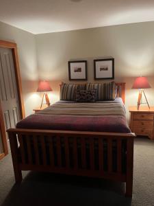 a bedroom with a large bed with two lamps at Wanna get away next Summer and Fall at the Crossing in Canmore