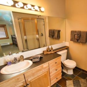 a bathroom with a sink and a toilet and a mirror at Canmore Crossing in Canmore