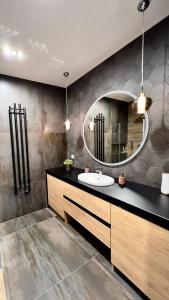 uma casa de banho com um lavatório e um espelho em Luksus w samym centrum em Breslávia