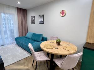 uma sala de estar com um sofá azul e uma mesa em Luksus w samym centrum em Breslávia