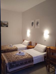 a hotel room with two beds and two tables at Villa Kaloudis Rooms in Agios Georgios