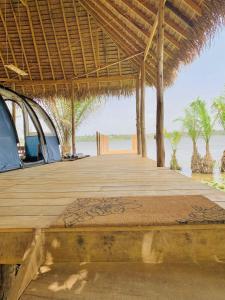 a wooden dock with a tent on the beach at Glamping Lakeview Ouidah in Gakpé