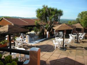 a patio with white chairs and tables and umbrellas at La Liccia - Camping&Village in Santa Teresa Gallura