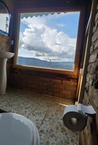 a bathroom with a window with a view of the ocean at Entre Rocas y Cristales in Ráquira