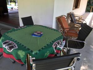 ボイトゥヴァにあるEspaço Sr Churras famílias são bem vindas Temos berçoの椅子とテーブル、緑のテーブルクロス