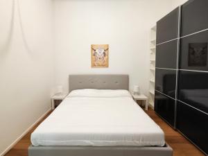 sypialnia z białym łóżkiem i dwoma stołami w obiekcie Casa di Matteo Ponterotto 34(zona brignole) w Genui