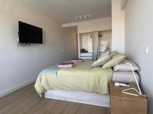 um quarto com uma cama e uma televisão de ecrã plano em Estudio renovado con vista al mar em Torremolinos