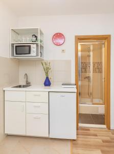 uma cozinha branca com um lavatório e um micro-ondas em BIS Apartment 3 em Dubrovnik