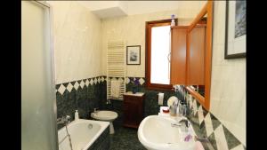 a bathroom with a sink and a tub and a toilet at Biennale Venice Charme Apartment in Venice +30 photos
