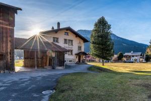 a large house with the sun shining on it at Florin Ferien in Klosters