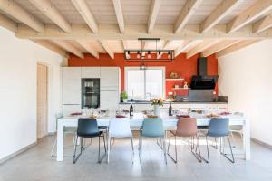 een keuken met een witte tafel en stoelen bij Les Balcons de la Charve - Gîte 4 étoiles in Jongieux
