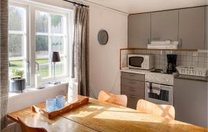uma cozinha com uma mesa de madeira e uma cozinha com um fogão em 2 Bedroom Awesome Home In Vstervik em Västervik