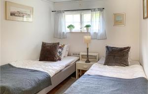 2 Betten in einem kleinen Zimmer mit Fenster in der Unterkunft 2 Bedroom Awesome Home In Vstervik in Västervik