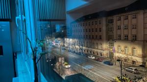 una ventana con vistas a una calle de la ciudad por la noche en Luxury Apart Dorobanți, en Bucarest