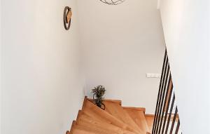 a wooden staircase with a clock on the wall at Amazing Home In Radziechowy With Kitchen in Radziechowy