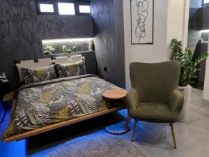 um quarto com uma cama e uma cadeira em Apartman Biblioteka em Novi Beograd